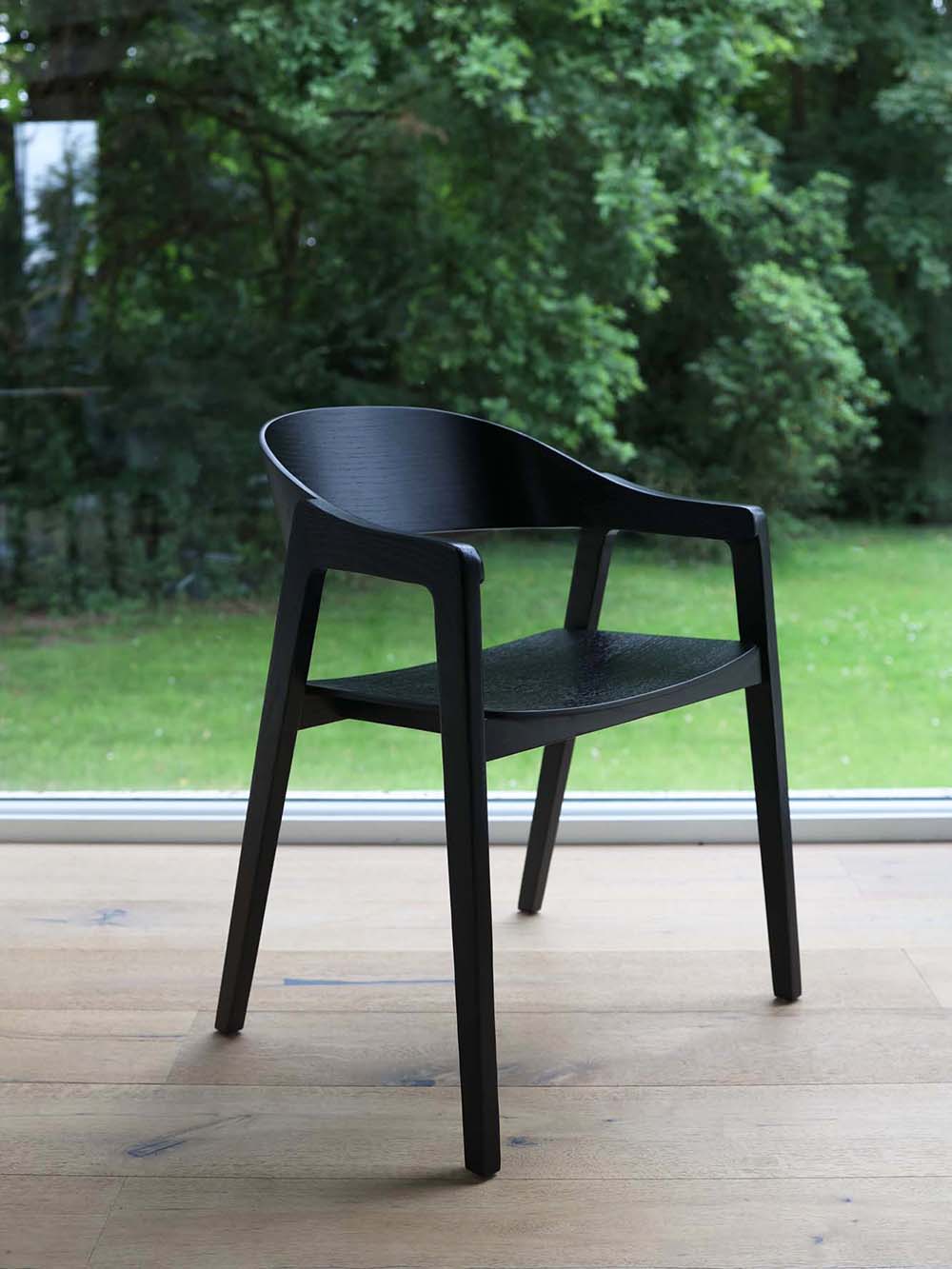 Ontdek de Cielo, een zwarte afgeronde stoel met een eikenfineer zitting en rugleuning, ondersteund door stevige massief eikenhouten poten. Ervaar de perfecte combinatie van elegantie en comfort met deze veelzijdige en verfijnde stoel!